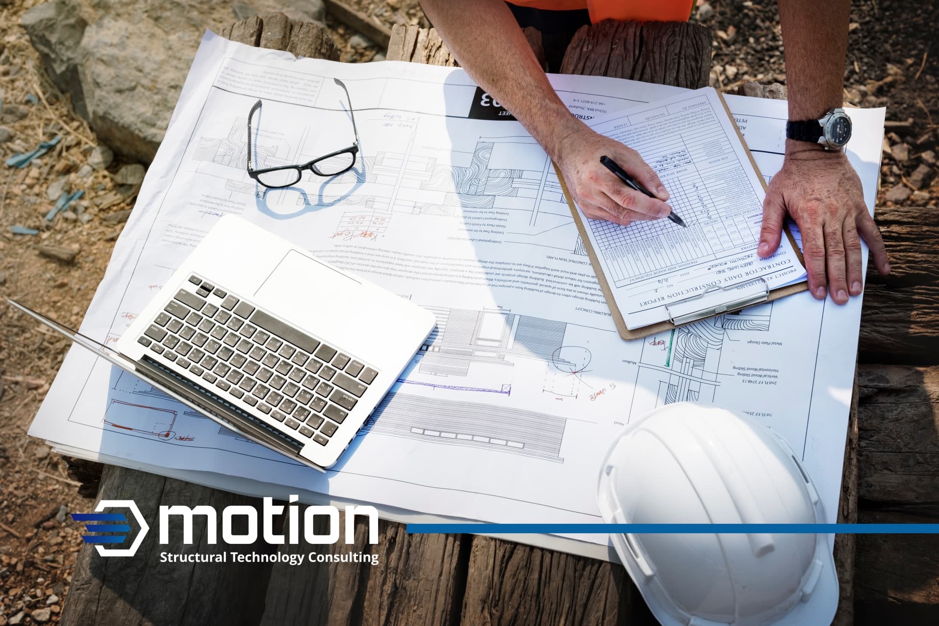 Technical drawings on a table with an engineer writing, featuring glasses, a safety helmet, and STC Motion's logo overlay.