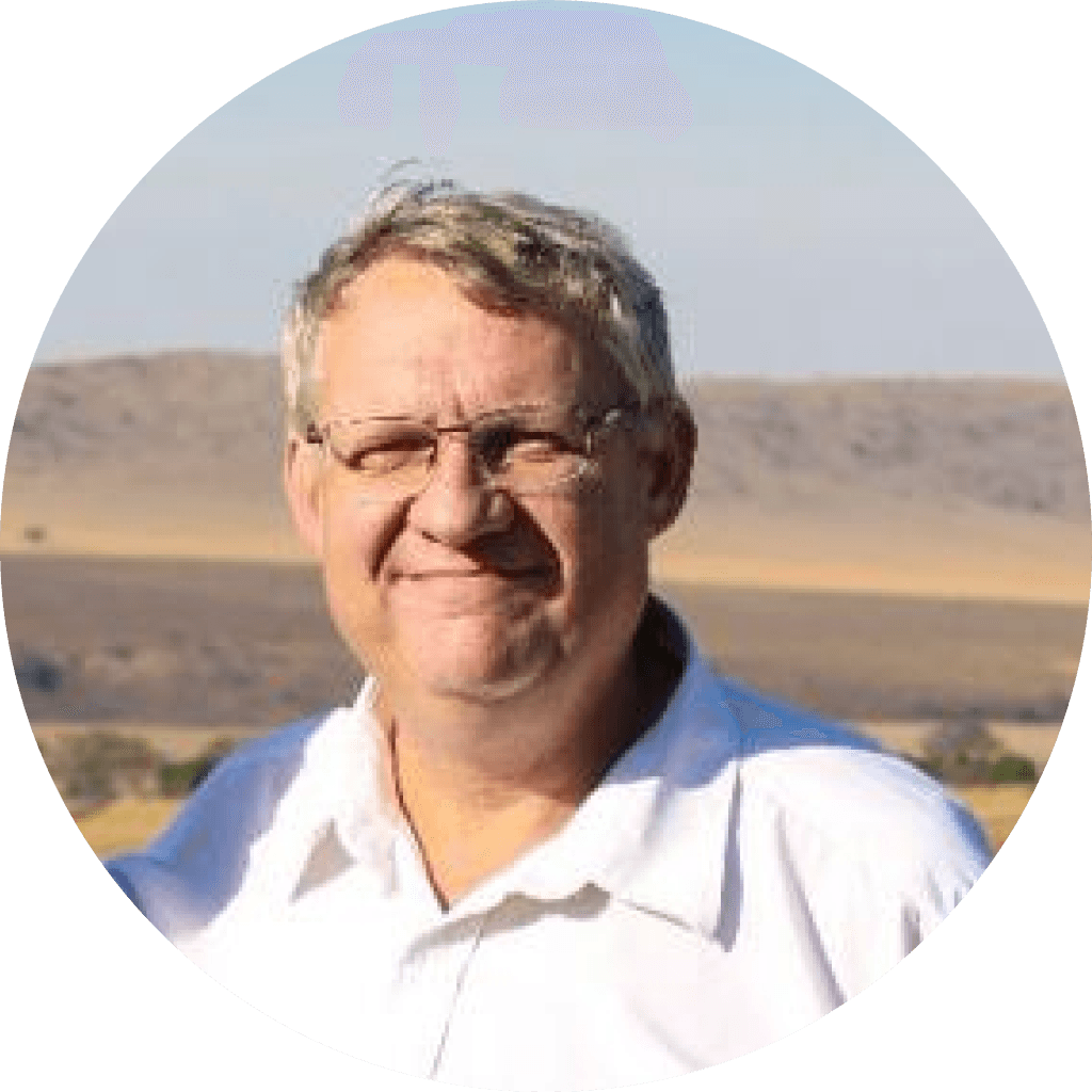 Headshot of Hendrik Stockigt, director of STC Motion, poses in a white shirt and glasses, with a field visible in the background.